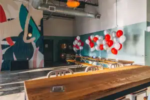 Colorful balloons decorate a trendy Toronto nightclub with urban art wall for a lively night scene.