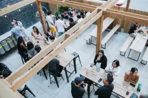 Vibrant outdoor patio at Toronto nightclub with groups of friends enjoying drinks and socializing.