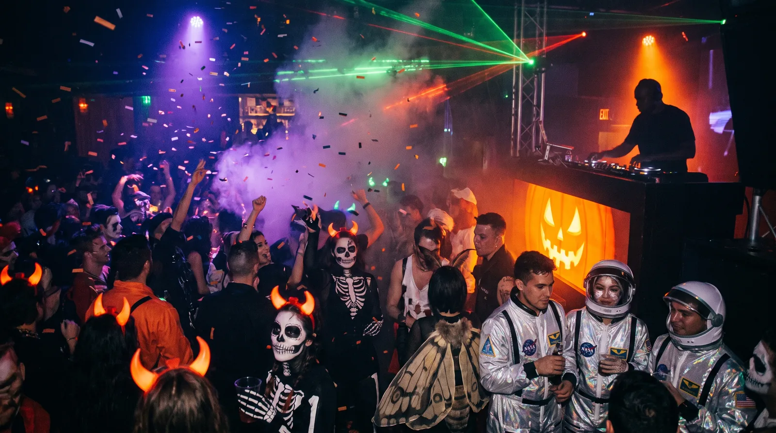 Packed Toronto nightclub dance floor under red and amber lights on a big party weekend